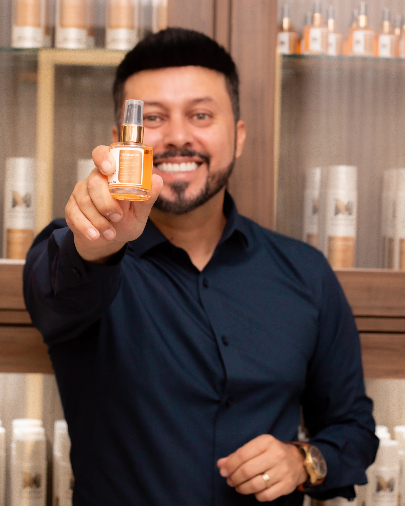 Michaell Douglas segurando o frasco do Óleo Reparador Premium, da linha profissional